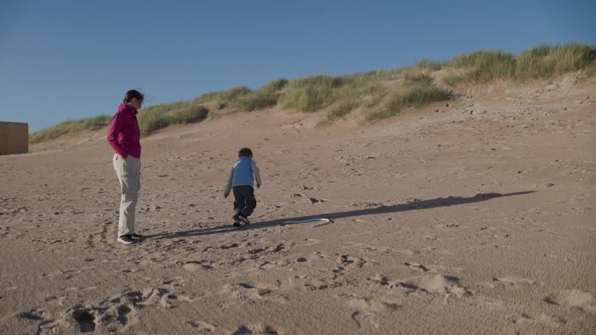 Mother and son playing on sandy beach