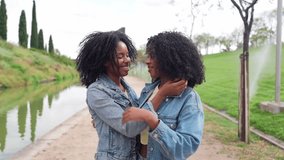 African two happy twin sisters are laughing and enjoying each other's company in a beautiful park setting - Powered by Shutterstock - Get 15% off with code: PIKWIZARD15