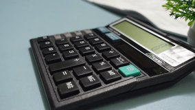 Calculating Taxes with Money and Calculator. Close up of hand using calculator on work desk - Powered by Shutterstock - Get 15% off with code: PIKWIZARD15