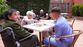 Nurse, daughter and senior women playing a board game in the garden of a nursing home, enjoying leisure time and social interaction - Powered by Shutterstock - Get 15% off with code: PIKWIZARD15