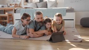 Video of father with three daughters watching tv show on tablet. - Powered by Shutterstock - Get 15% off with code: PIKWIZARD15