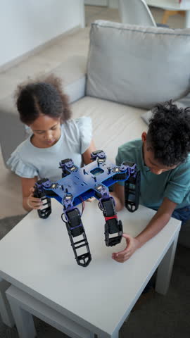 Kids building their first homemade robot at home.