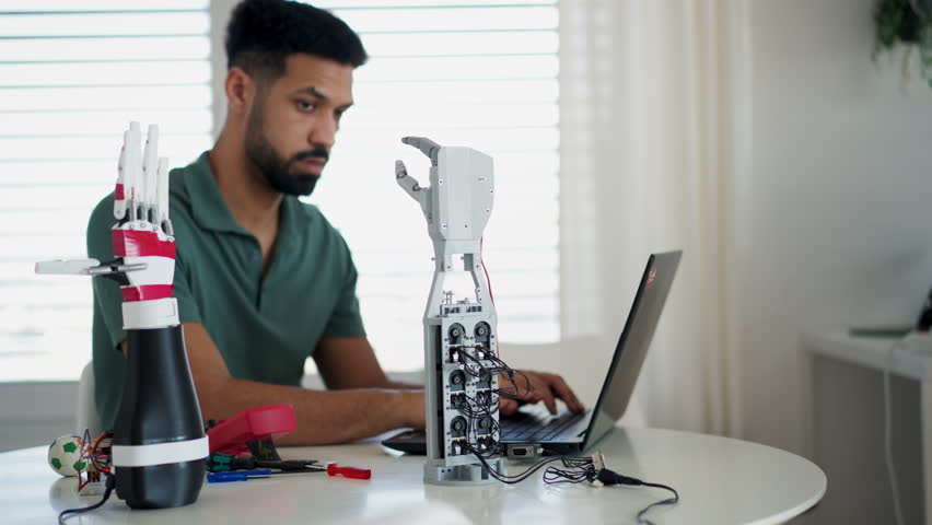 Young engineer building and programming a robotic arm at home.