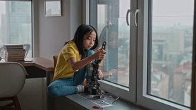 Japanese gril playing with her homemade robot at home. - Powered by Shutterstock - Get 15% off with code: PIKWIZARD15