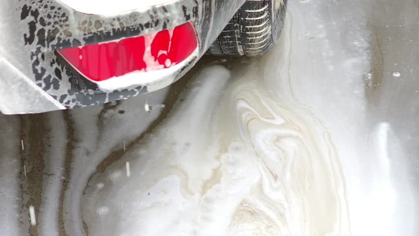 Car wash soap suds flowing on concrete