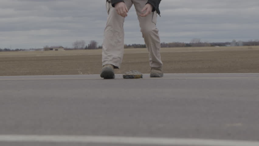 PIcking up a turtle on the road to save it