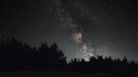 Beautiful night sky time lapse with Milky Way galaxy over forest.  Night tight landscape starry sky. - Powered by Shutterstock - Get 15% off with code: PIKWIZARD15