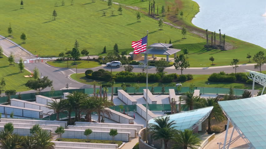 Army veteran cemetery with white headstones and USA flag. Tombs of retired military soldiers. Memorial Day concept.