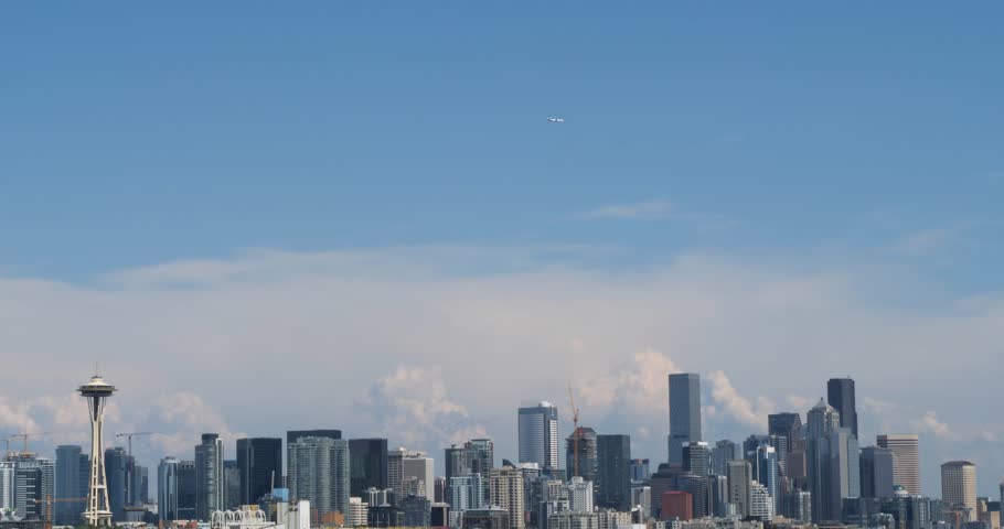 Airliner flying over Seattle.City skyline, viewed from Elliott Bay, Seattle, Washington.