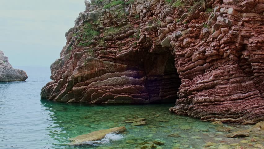 Beautiful rocks and bright turquoise water among layered rocks near Budva, Montenegro. Tropical summer landscape exotic beach on the Adriatic Sea. Vacation