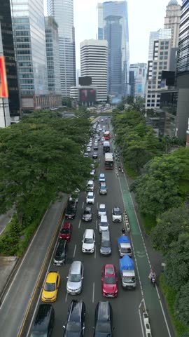 FPV drone flight over busy multilane street with morning traffic and motorbike lane in central business district of Jakarta, Indonesia. Ideal for transport and infrastructure themes.