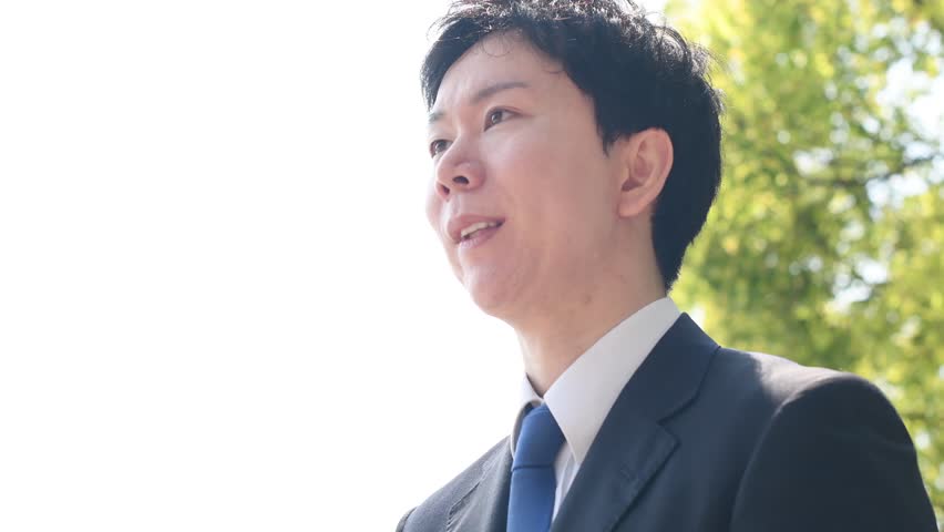 A young Asian man in a suit, a troubled businessman