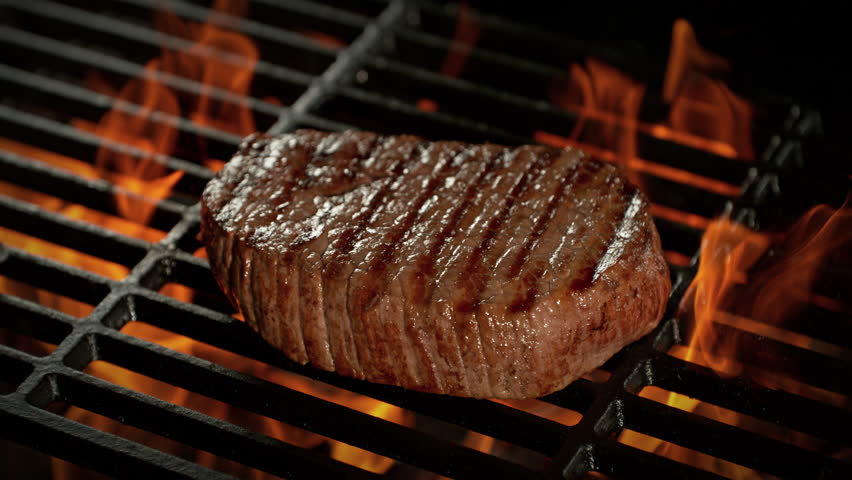 Super Slow Motion Shot of Flipping Beef Steak Meat on Grill with Camera Motion at 1000fps.