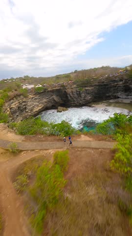 FPV drone flight over Broken Beach and Angel's Billabong on Nusa Penida, Bali. Famous coastal rock formation with natural arch and turquoise waters. Ideal for travel and nature themes.