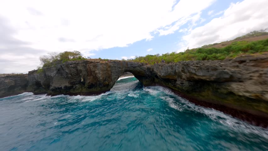 FPV drone flight over Broken Beach and Angel's Billabong on Nusa Penida, Bali. Famous coastal rock formation with natural arch and turquoise waters. Ideal for travel and nature themes.
