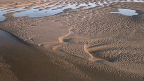 Tidal sand ripples with seawater pools at golden hour. Fast flight over. - Powered by Shutterstock - Get 15% off with code: PIKWIZARD15