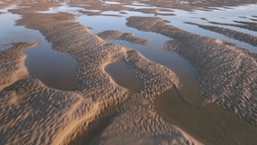 Seawater pools and tidal sand patterns at golden hour. Low fast flight over. - Powered by Shutterstock - Get 15% off with code: PIKWIZARD15