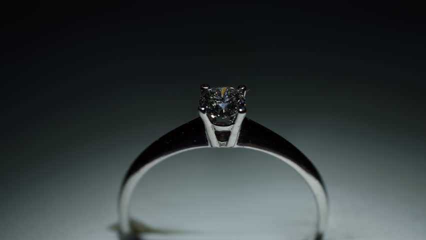 The shimmer of the facets of a diamond ring made of white gold or platinum under the influence of light.