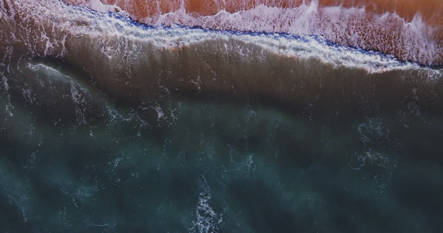 Aerial view from above of slow motion waves crashing and foaming on beach sand,Amazing sea nature background,High angle view beach sea from drone camera 4k High quality footage ProRes 422