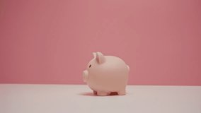 Close up of hand dropping an baht coin into a pink piggy bank. Financial and Business Safety Concept. - Powered by Shutterstock - Get 15% off with code: PIKWIZARD15
