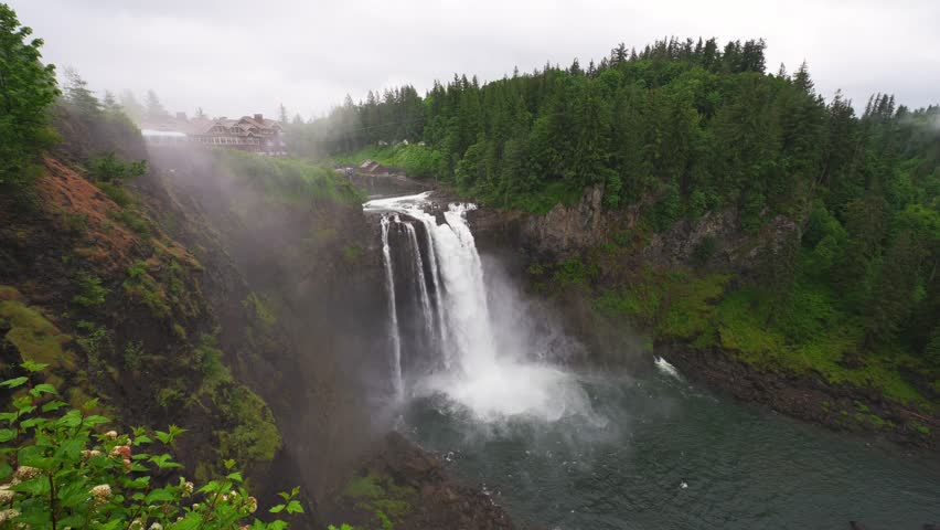 Snoqualmie Falls waterfall with lush greenery and mist in Washington State, USA. Snoqualmie Falls is a 268-foot waterfall on the Snoqualmie River between Snoqualmie and Fall City. 4K UHD video.