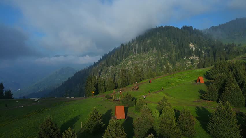 Stunning aerial and ground footage of Kok-Zhailau in Almaty, Kazakhstan. Campers set up tents in the mountains above the clouds, near Kumbel Peak and Three Brothers Ridge