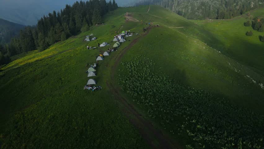 Stunning aerial and ground footage of Kok-Zhailau in Almaty, Kazakhstan. Campers set up tents in the mountains above the clouds, near Kumbel Peak and Three Brothers Ridge