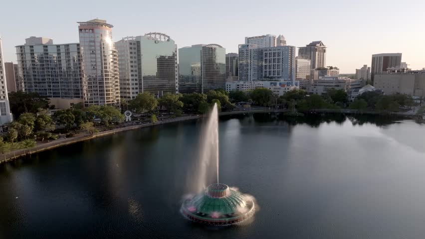 Downtown Orlando, Florida skyline with Linton E. Allen Memorial Fountain in Lake Eola and drone video pulling back.