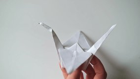 Folding a paper origami white crane, close-up - Powered by Shutterstock - Get 15% off with code: PIKWIZARD15