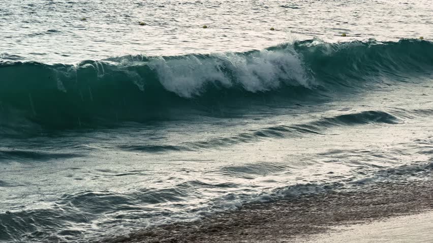 Rain at sea. Dark storm clouds, rain, and sea surface at sunset. Waves crashing on the shore. Natural background. Storm at sea. High quality 4k footage