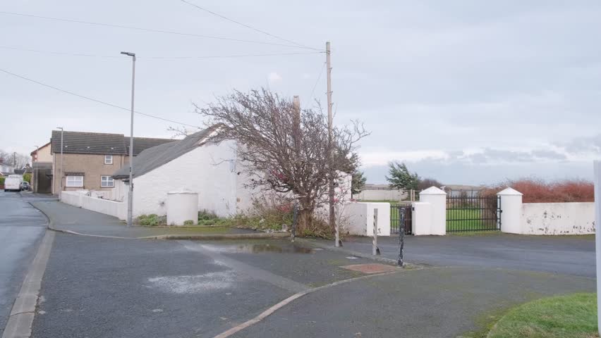 Quiet street corner with a white house and bare Fairy tree in Northern Ireland
