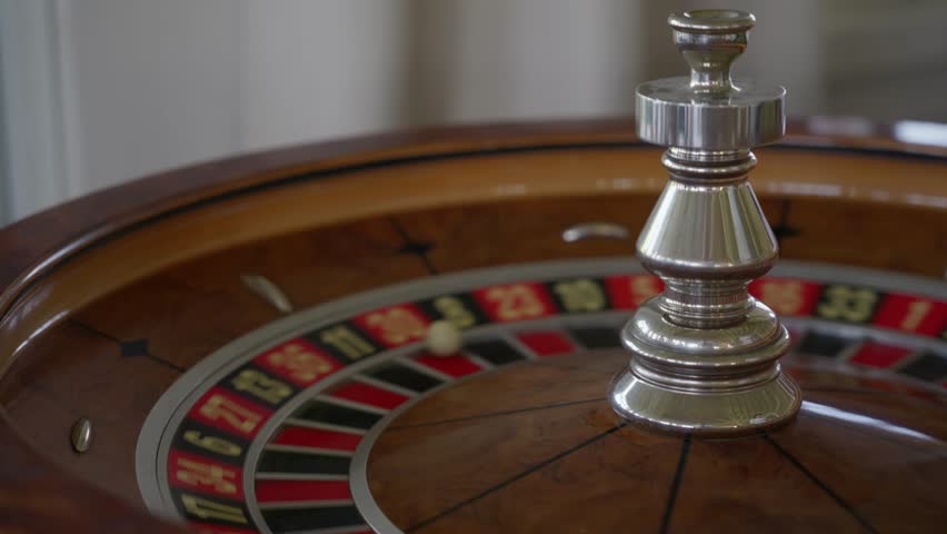 The roulette wheel slows down and the ball finally lands on 30 red. A moment of tension and anticipation in the elegant casino interior. High quality 4k footage