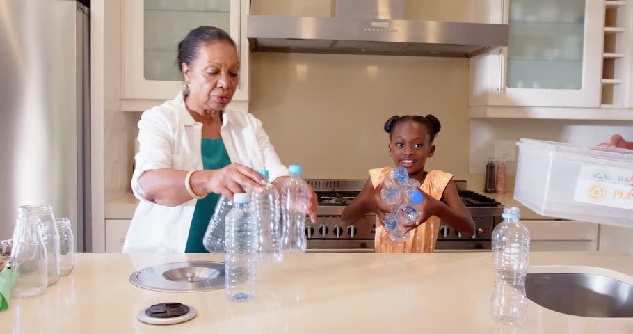 Teaching sustainability, diverse grandparents sorting plastic bottles for recycling, kitchen, home. environment, waste management, eco-friendly, education, conservation, family