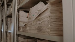 Large stack of documents neatly piled on a metal shelf in an archive room, with colored stickers separating sections. - Powered by Shutterstock - Get 15% off with code: PIKWIZARD15