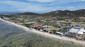 Semi orbit drone movement revealing the colorful patchwork of farmlands and My Hoa Lagoon meeting at the shore under midday sun. My Hoa Vietnam, famous kitesurfing spot during low season. - Powered by Shutterstock - Get 15% off with code: PIKWIZARD15