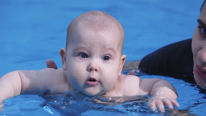 Baby swimming and playing with floating toy in pool