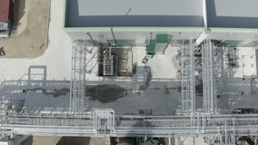 Top-down aerial tracking over complex network of pipes and industrial equipment on factory rooftop, workers visible, Castets, France - Powered by Shutterstock - Get 15% off with code: PIKWIZARD15