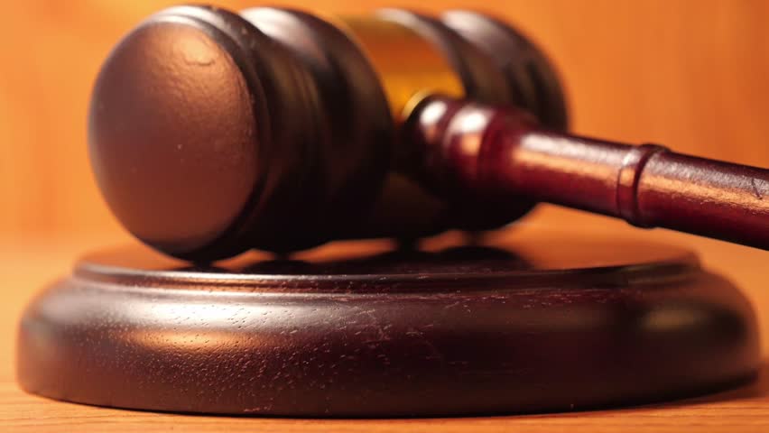 Slow-motion cinematography of a gavel's impact, as seen in depictions of judicial proceedings or auction events.