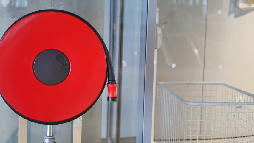 A red fire hose reel is installed in a modern building, emphasizing safety and emergency readiness