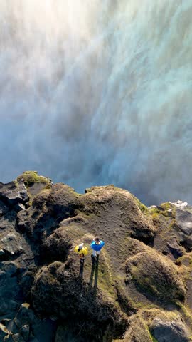 Visitors admire the breathtaking Dettifoss waterfall, known for its impressive power, while enjoying clear skies. The natural beauty of Icelands rugged landscape captivates all who visit.
