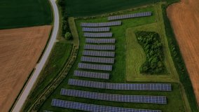 Solar farm from above with photovoltaic panels on green summer fields in rural Germany. Renewable energy, alternative power, eco-solution for climate protection and low-carbon living. - Powered by Shutterstock - Get 15% off with code: PIKWIZARD15