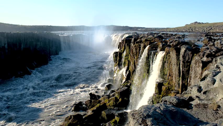 Witness the magnificent Dettifoss waterfall in Iceland, cascading down rugged cliffs into the roaring river below.