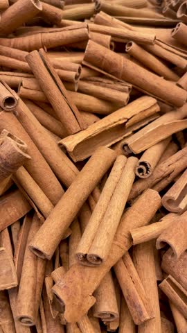 Close-up video of natural brown cinnamon sticks showing rich texture and woody detail. Ideal for culinary themes, spice backgrounds, or organic food visuals