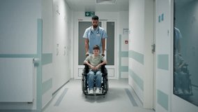 A doctor pushing boy in wheelchair through hospital corridor. - Powered by Shutterstock - Get 15% off with code: PIKWIZARD15