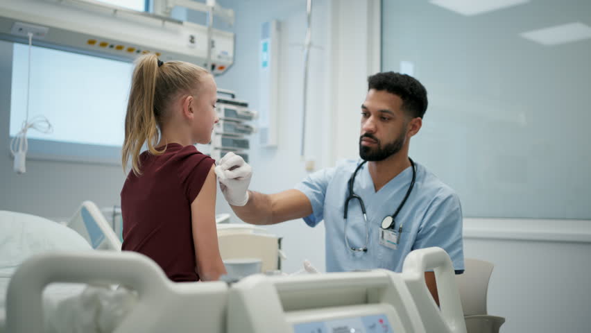 Doctor giving vaccine to young girl during childhood immunization.