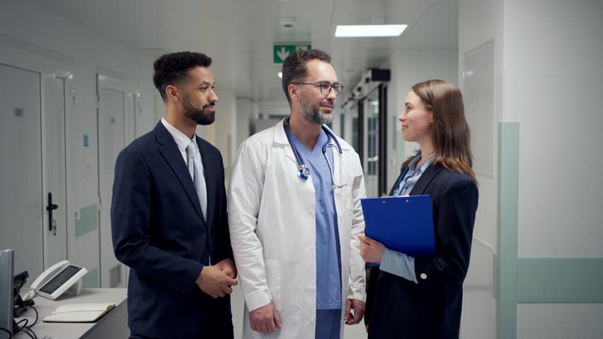 Pharmaceutical sales respresentatives with doctor in hospital.