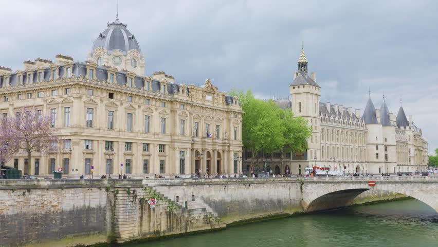 View of the bridge Pont au Change over the Seine River, embankment Quai de l'Horloge, buildings of the Tribunal de Commerce de Paris and the palace Conciergerie in the 1st arrondissement, Paris.