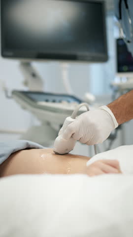 Doctor using ultrasound probe to check on young boy, abdominal ultrasound.