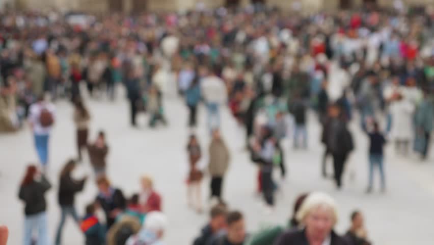 Crowd of tourists at the Place Jean-Paul II near the Catholic cathedral church Notre-Dame de Paris on the island Ile de la Cite, 4th arrondissement of Paris, France. Out of focus.