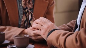 A loving elderly couple sharing a warm and affectionate moment while holding hands, radiating joy and connection, as they celebrate their romance during an intimate date on a lovely terrace - Powered by Shutterstock - Get 15% off with code: PIKWIZARD15